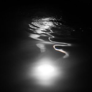 Reflejo de luz subacuatica en pesca nocturna