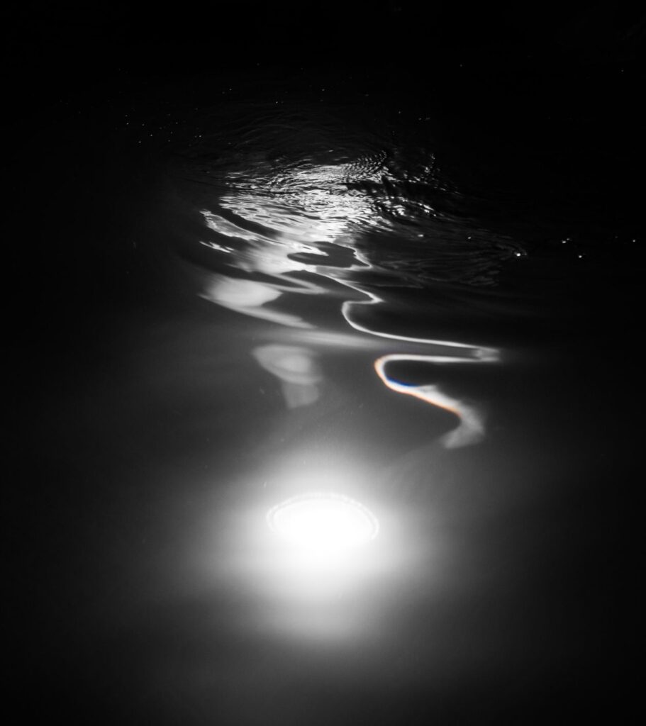 Reflejo de luz subacuatica en pesca nocturna